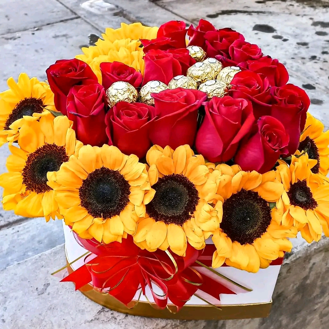 Arreglo floral con rosas, girasoles y chocolates